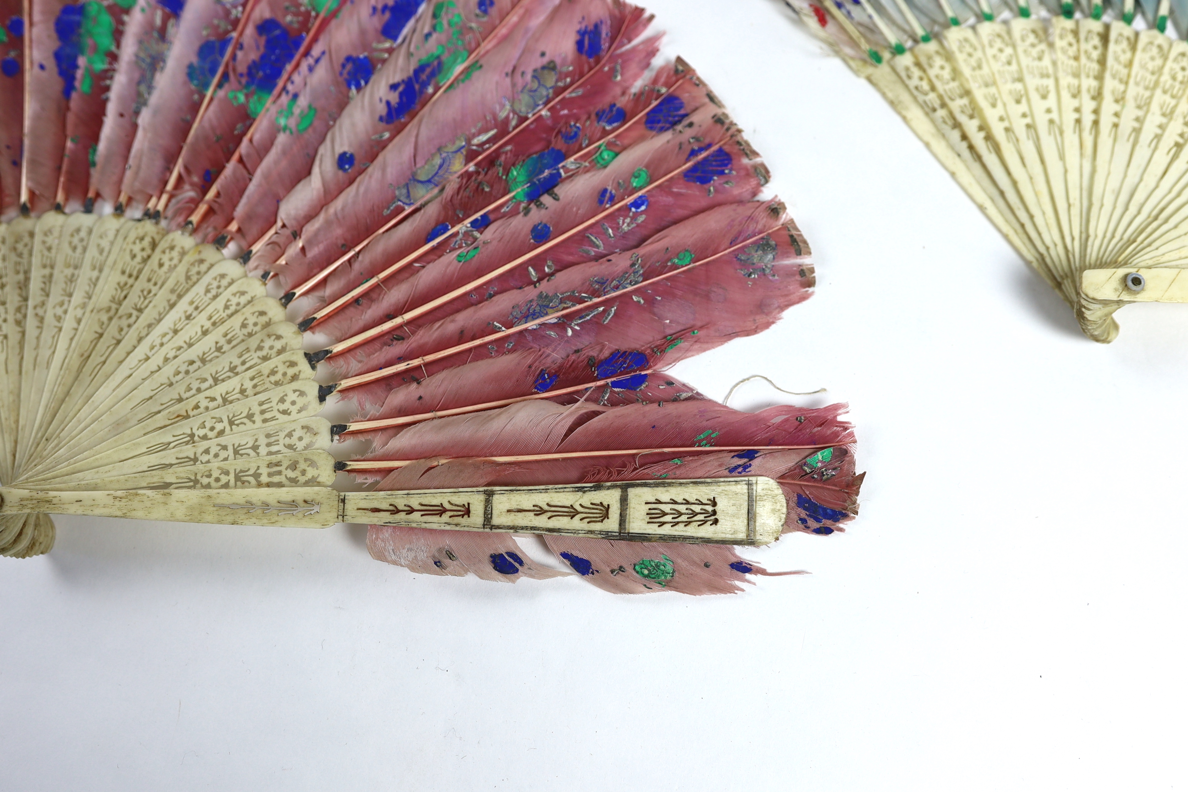 Two 19th century Chinese painted feather with bone brisé guards, one painted with a central figural cartouche, the other flowers